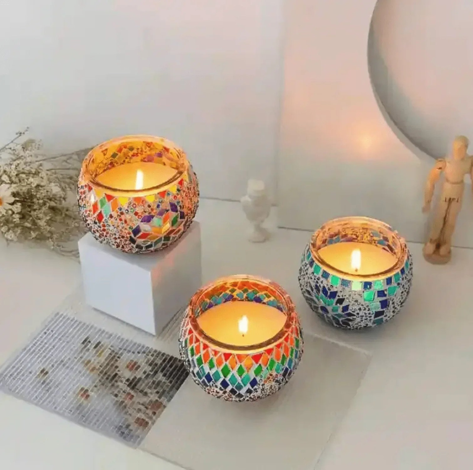 Three lit candles in mosaic holders
