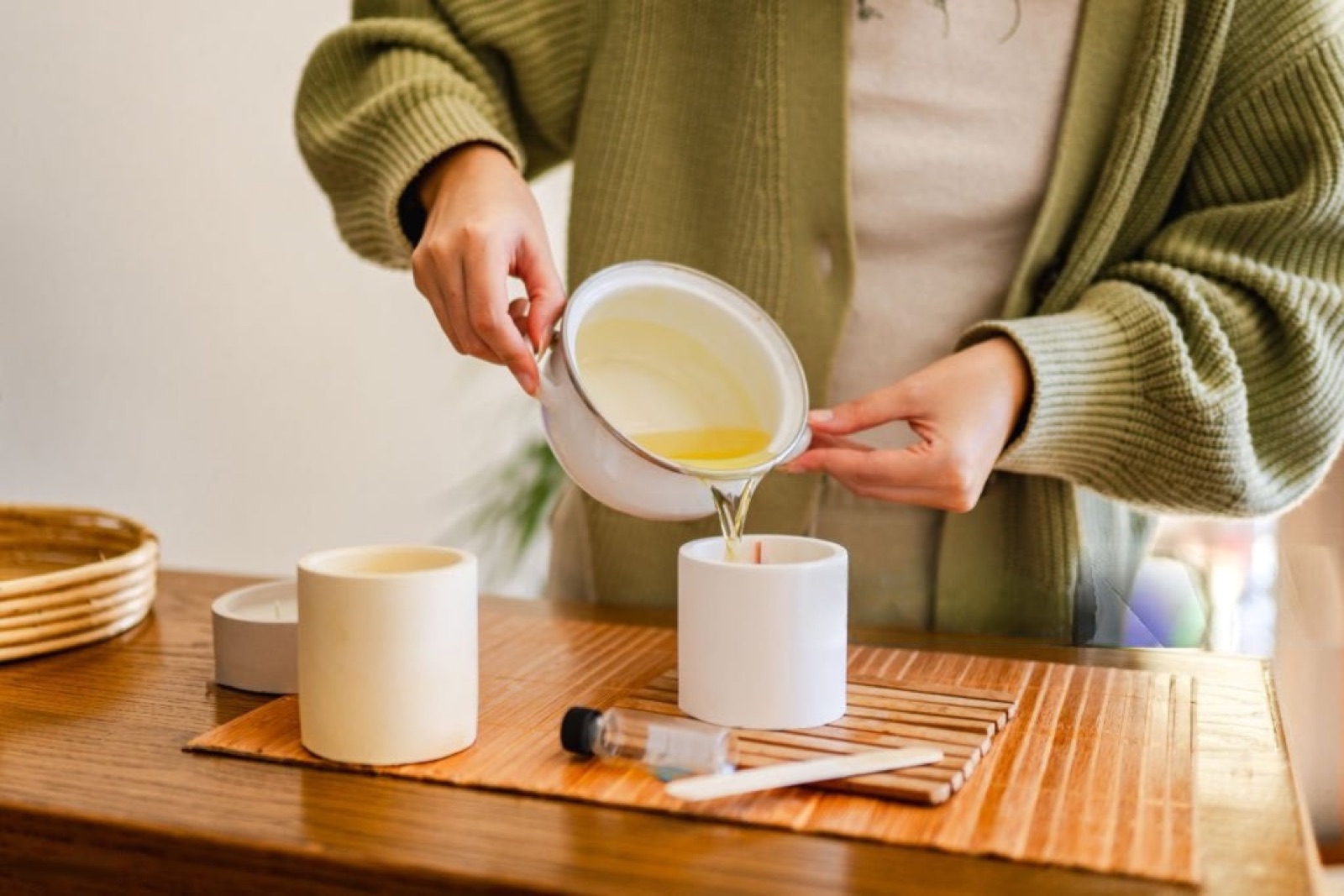 Pouring melted wax into a candle vessel