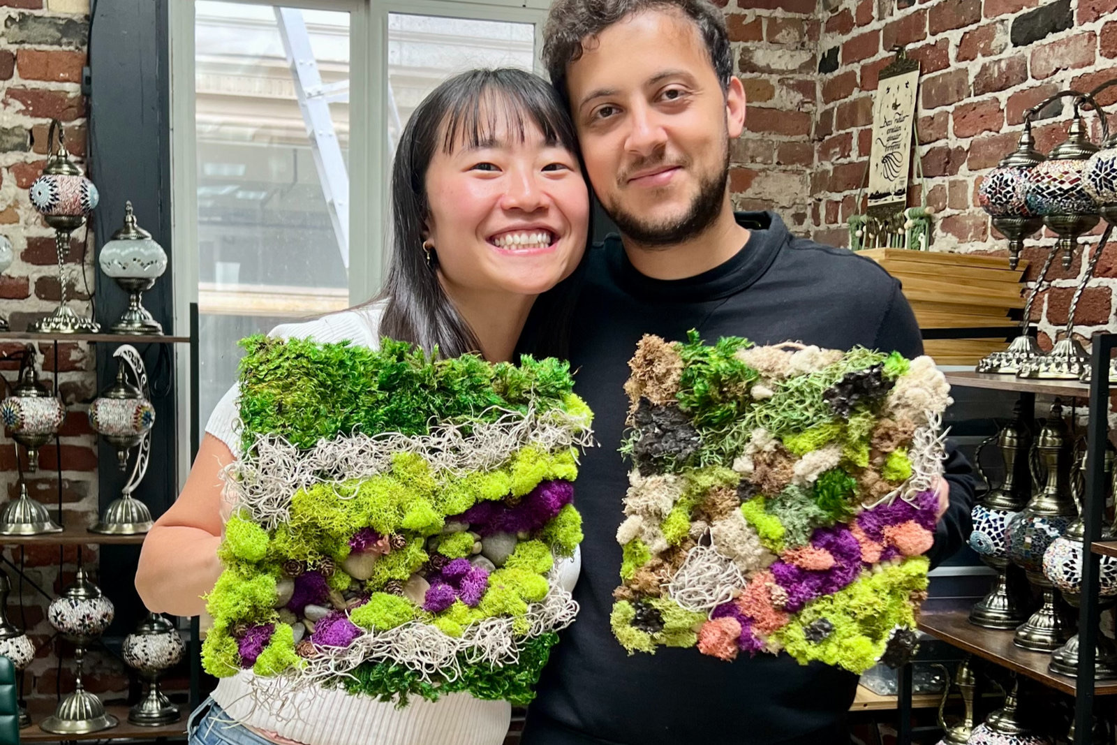 Two teammates with the moss art they made