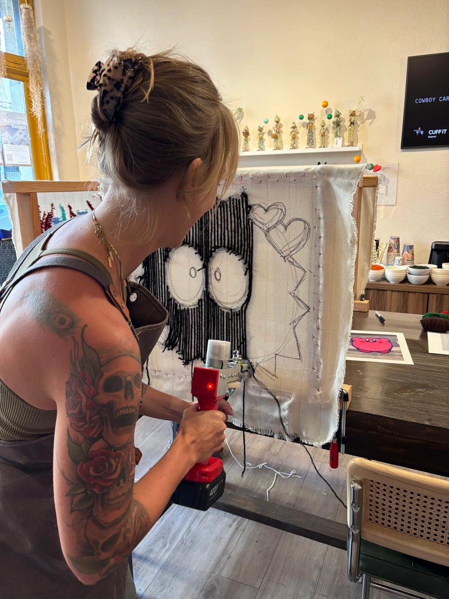 Tufting a design into cloth on a frame with a tufting gun
